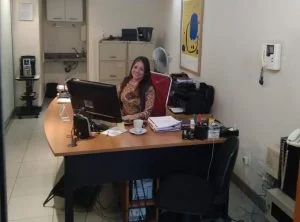 funcionária da uniprest sorrindo atrás de uma mesa de escritório